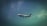 A commercial airplane is flying in the sky, featuring the logo and branding of an airline company on its fuselage. The aircraft is captured against a backdrop of a gradient sky transitioning from a dark to light blue hue with clouds visible.