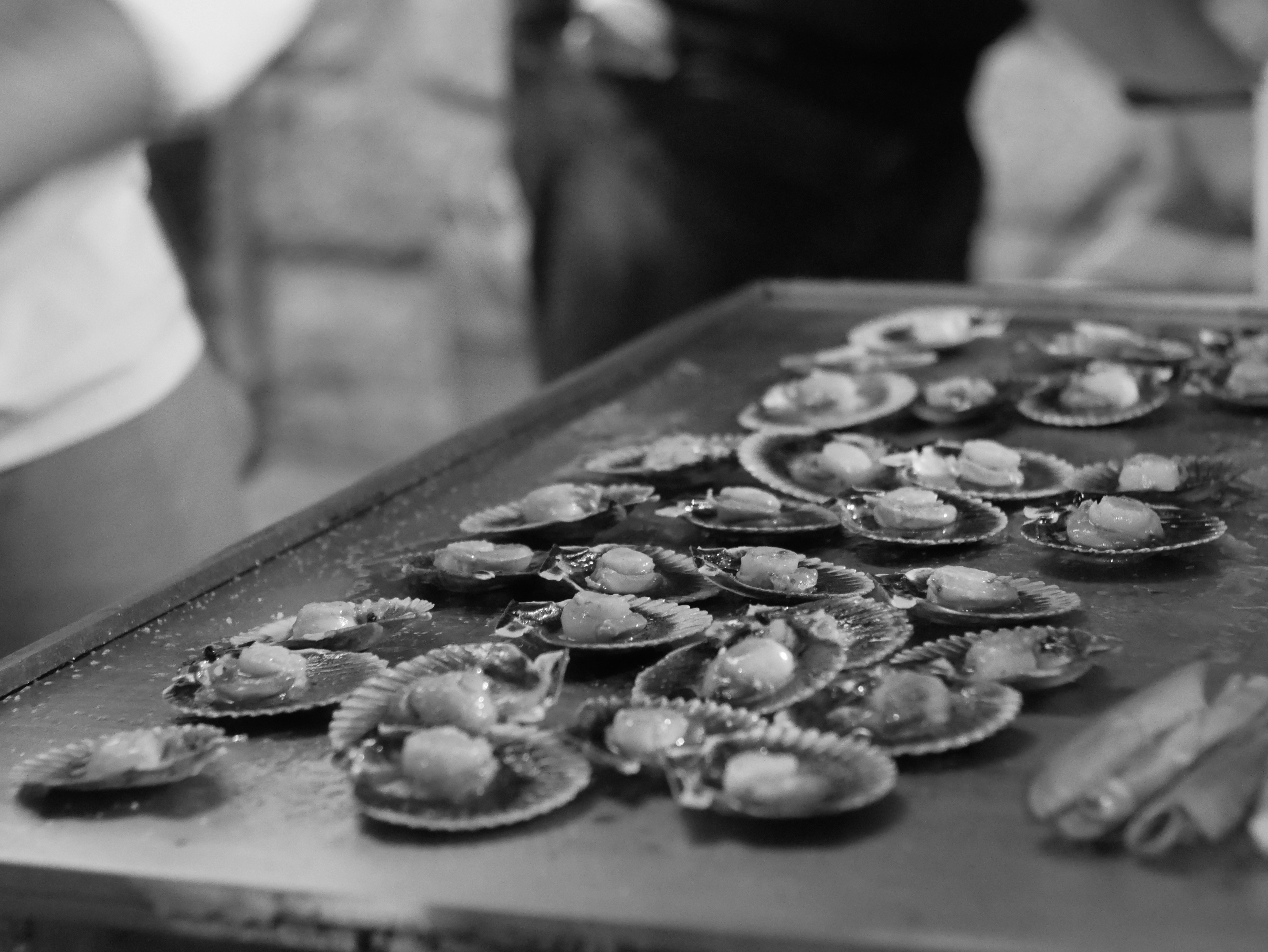 a table topped with lots of clams on top of a pan