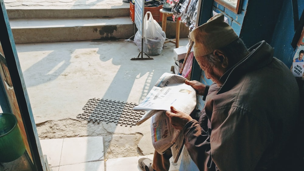 um homem sentado em um banco olhando para um pedaço de papel