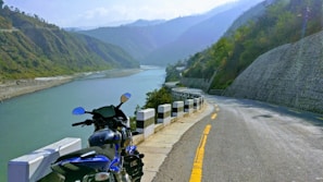 A scenic road winding through green hills, perfect for a motorcycle ride.