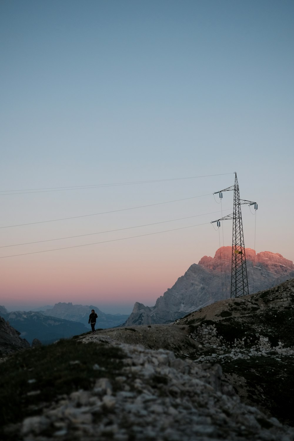 person standing beside tower line