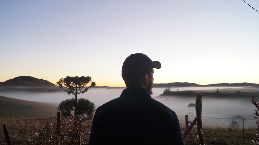 man standing beside lake