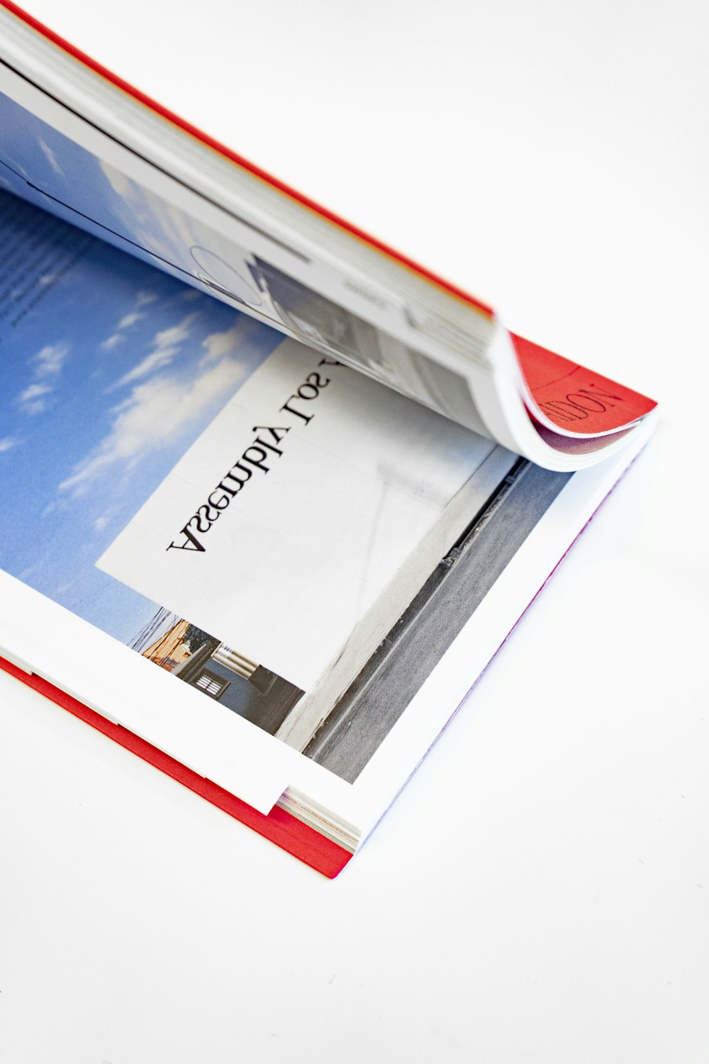 an open magazine with a red cover on a white table
