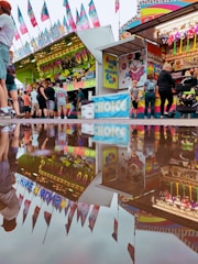 Colorful carnival scene with guests interacting with AR elements through handheld devices.