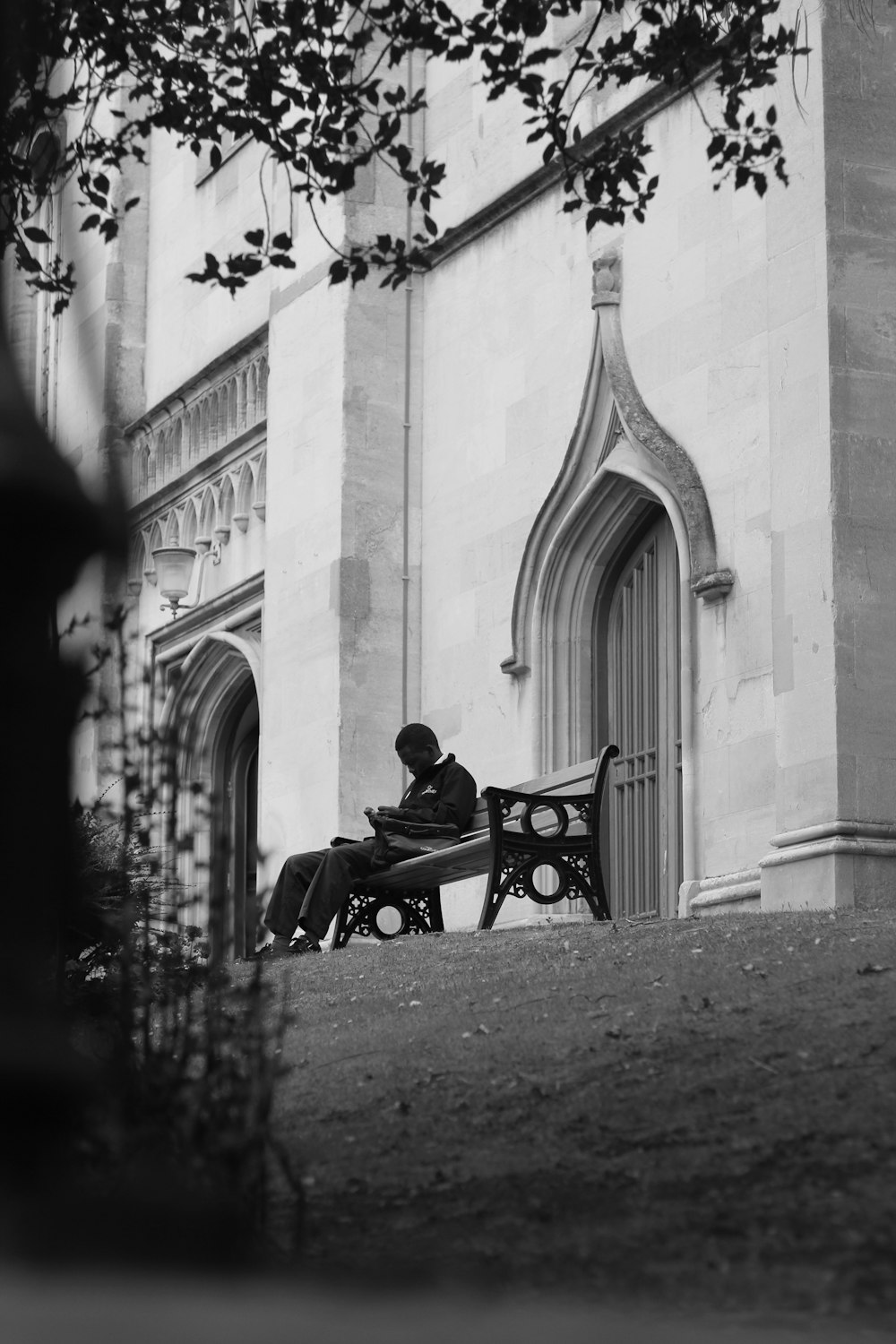 a person sitting on a bench in front of a building