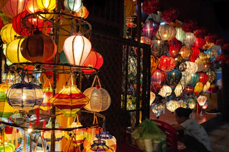 A cozy corner with folded traditional outfits stacked neatly next to a glowing lantern.
