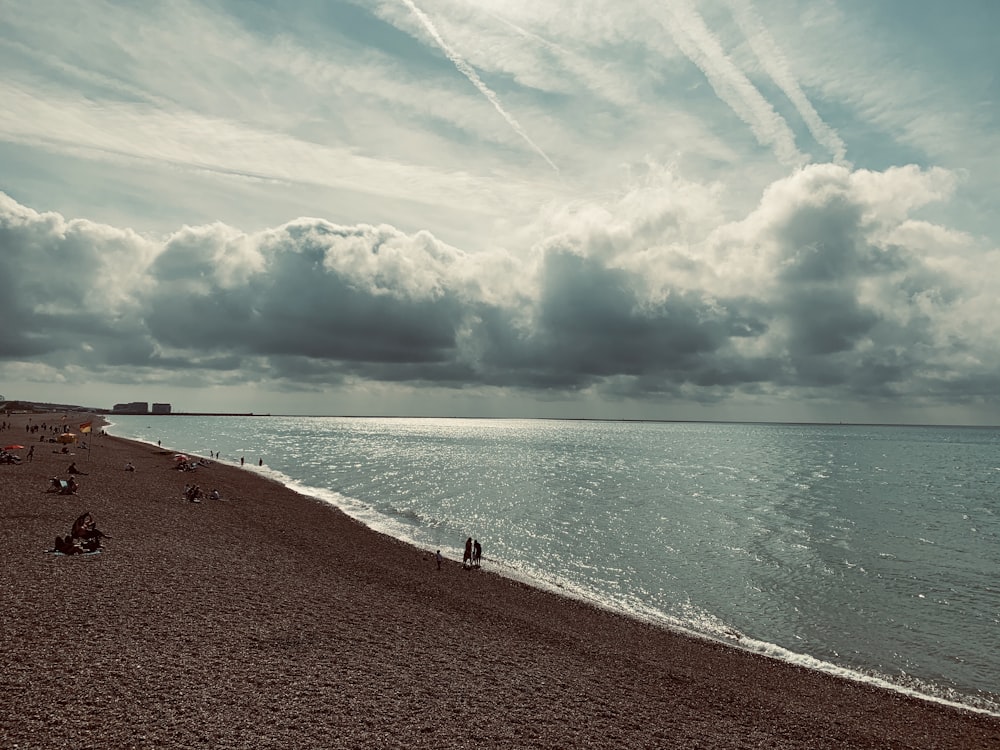 people on seashore across horizon during daytme