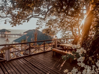 A serene view of the pousada's elegant wooden deck overlooking the lush Amazon rainforest at sunset.