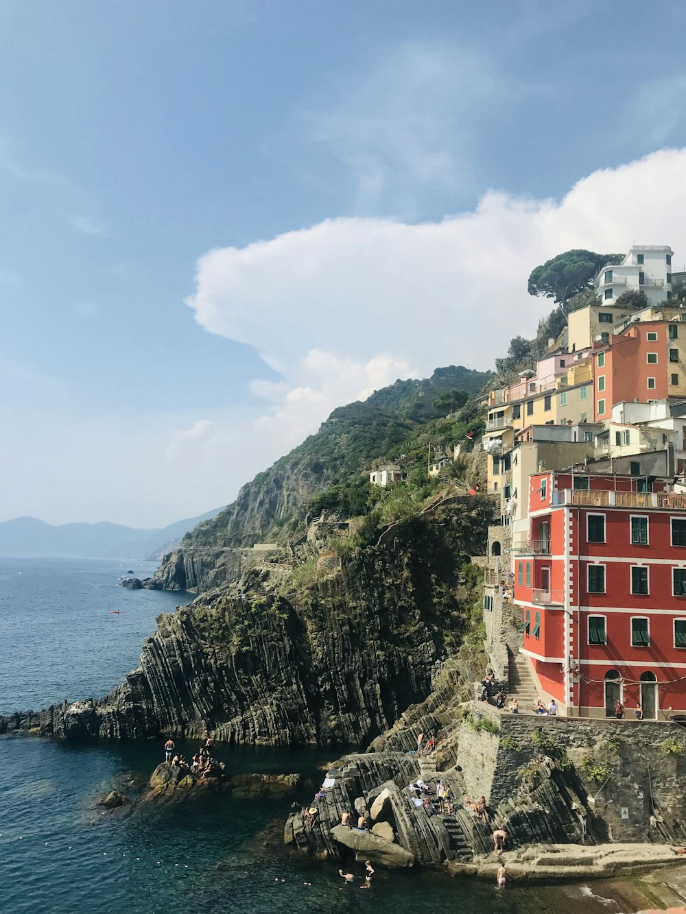 Bâtiment en béton rouge et blanc près d’un plan d’eau pendant la journée