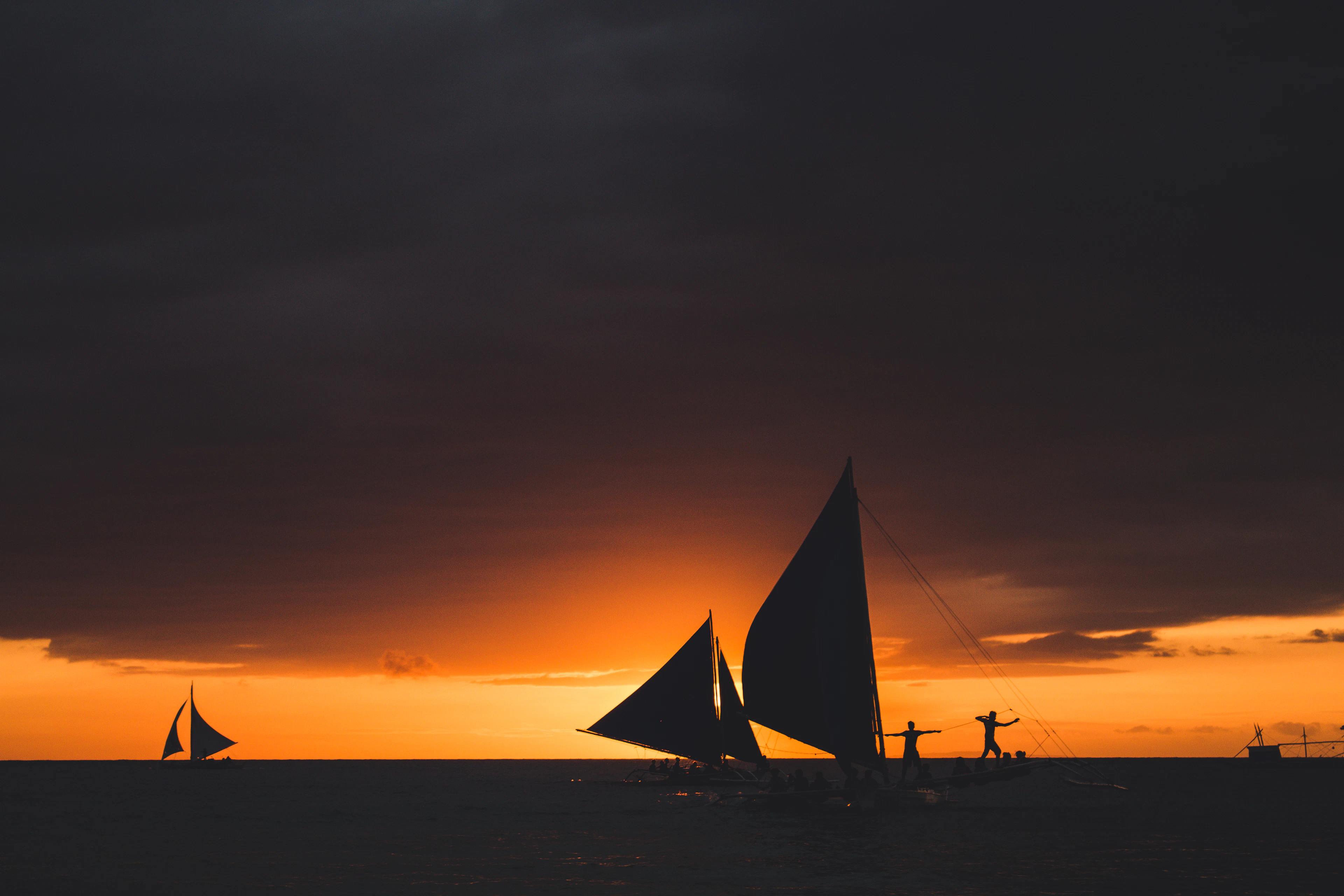 Paraw outriggers sailing off White Beach at sunset, Boracay
