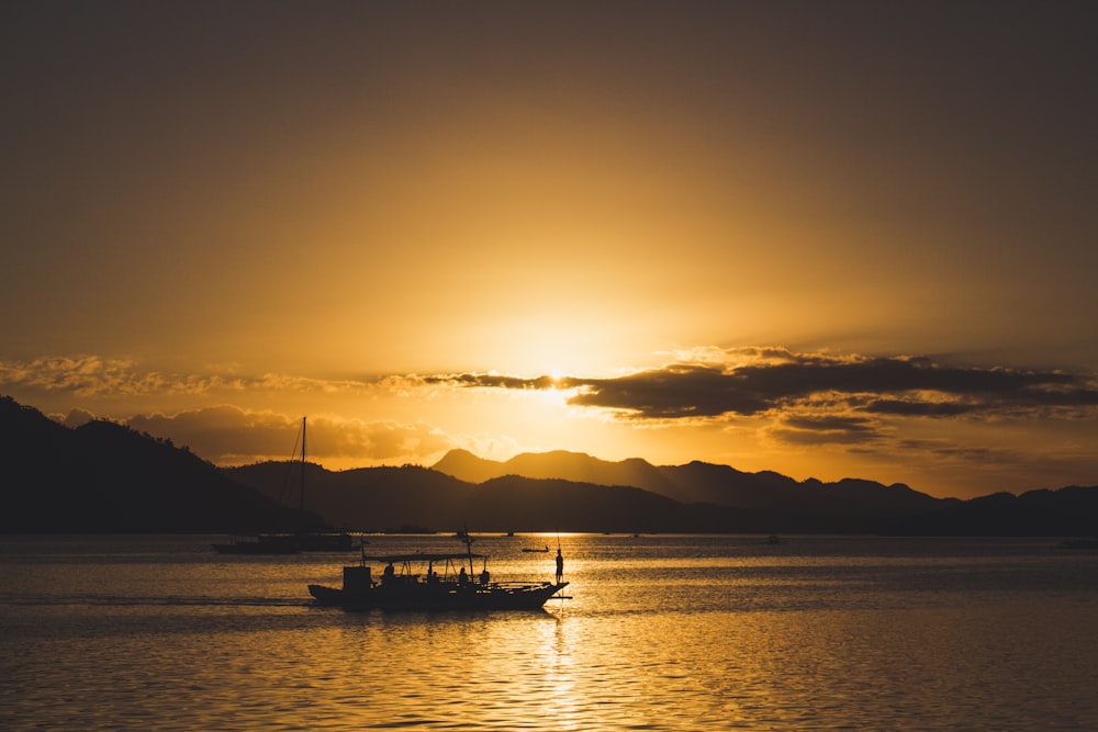 silhouette photography of body on body of water