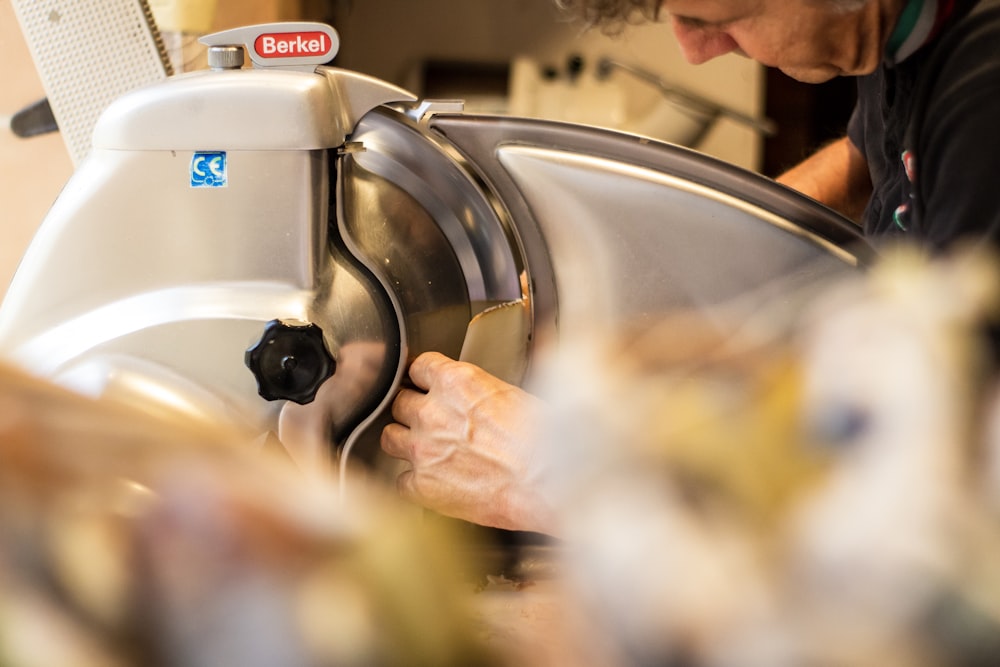 a man working on a dishwasher in a kitchen