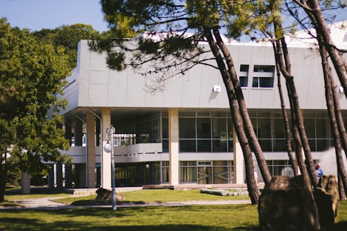 Wide-angle shot of a minimalist building surrounded by greenery.