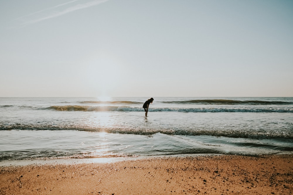 silhouette of person standing on seashore