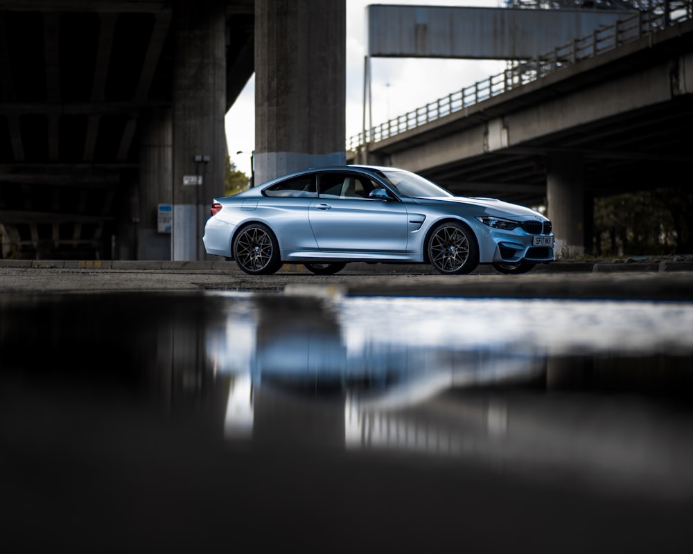 blue coupe under bridge