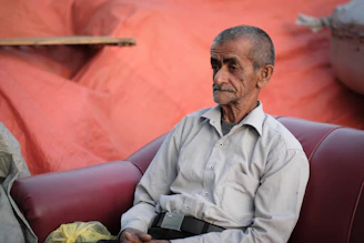 An older adult engaged in a calm coaching session at home, with soft blue and green decor in the background.