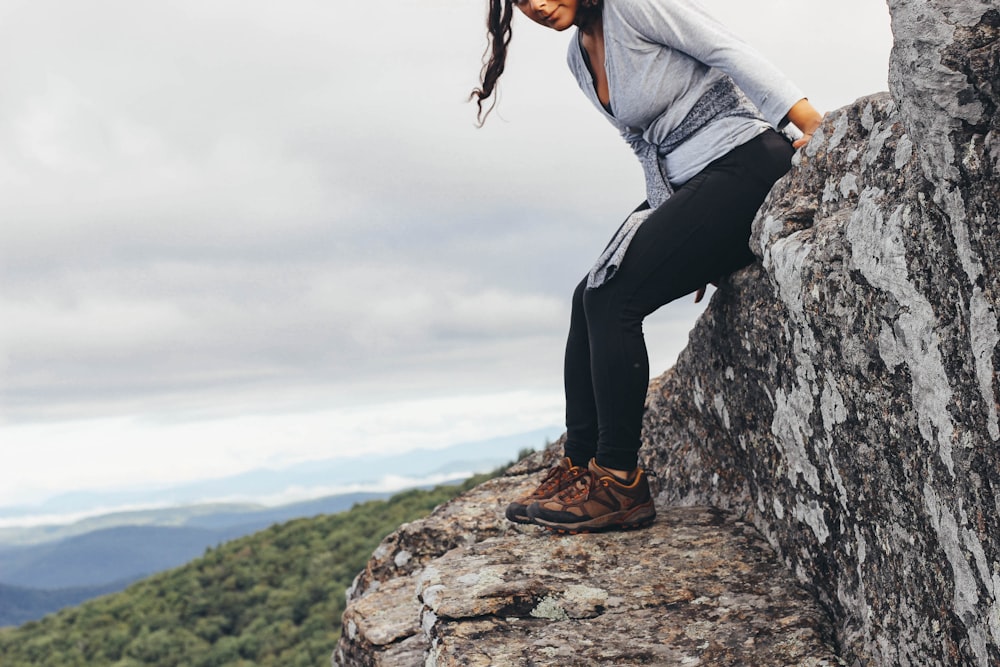 woman sitting on rock