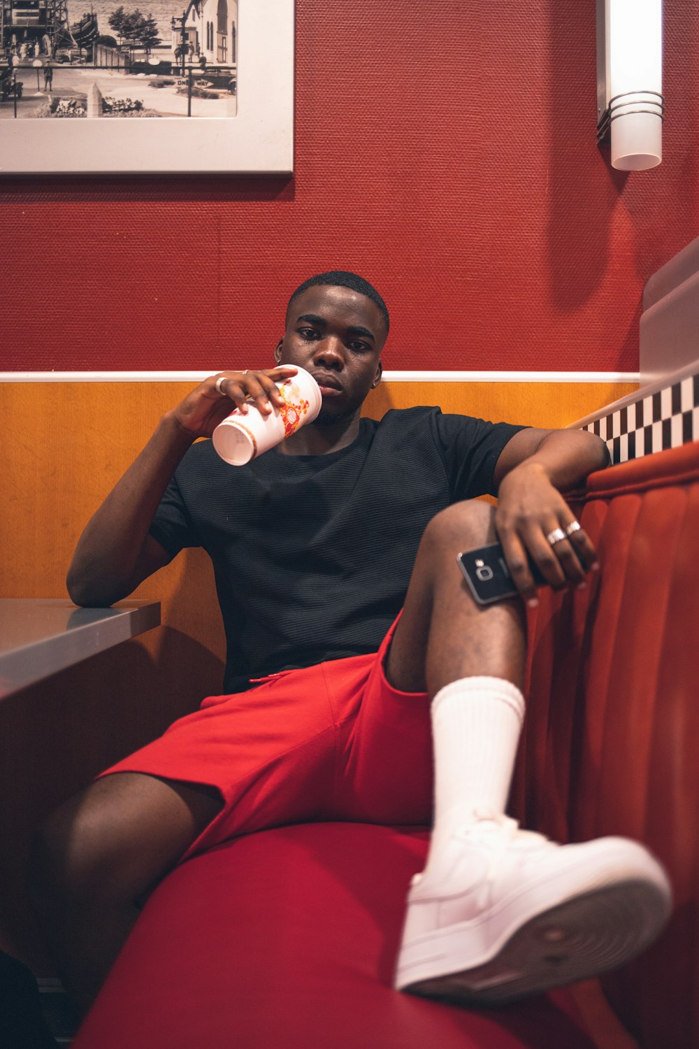 man sipping and sitting on sofa