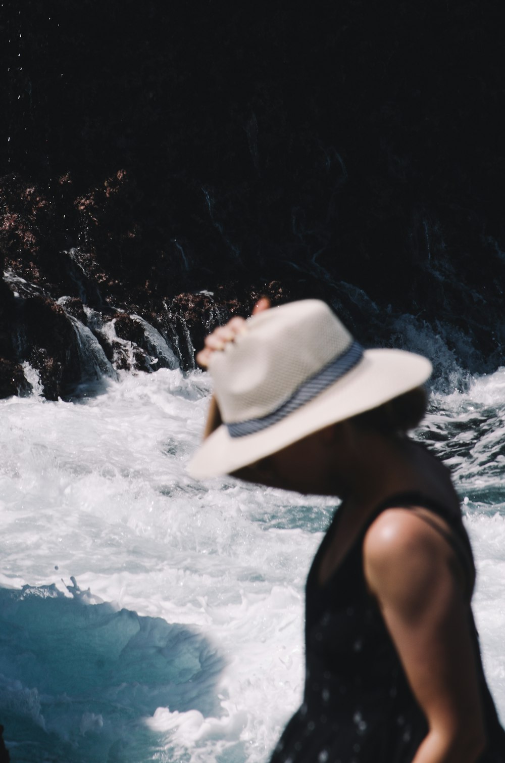 foto a fuoco superficiale di persona in camicia nera senza maniche vicino allo specchio d'acqua