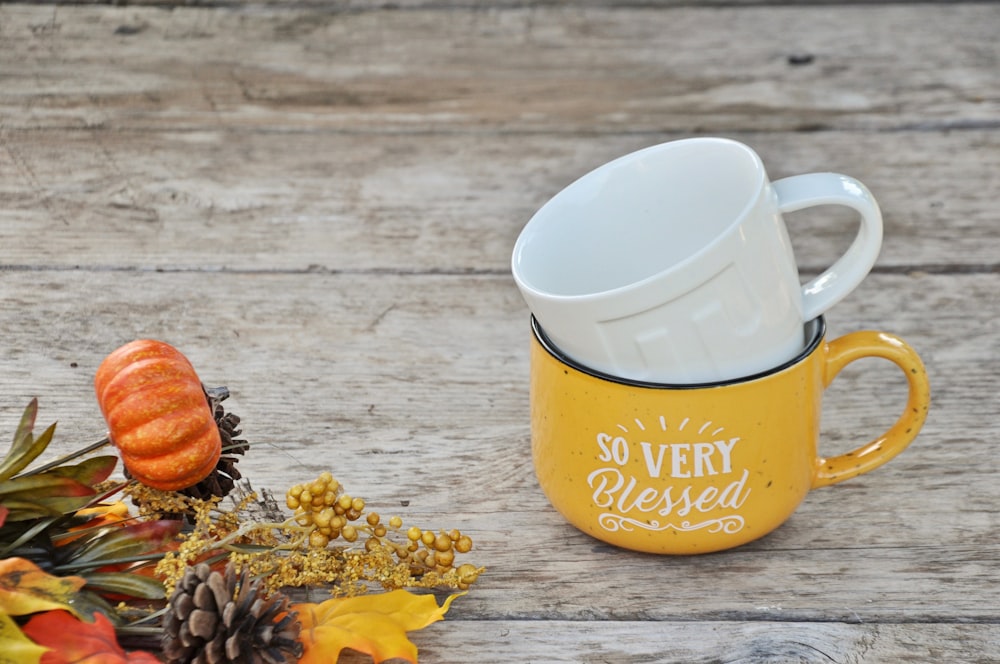 two white and yellow ceramic mugs