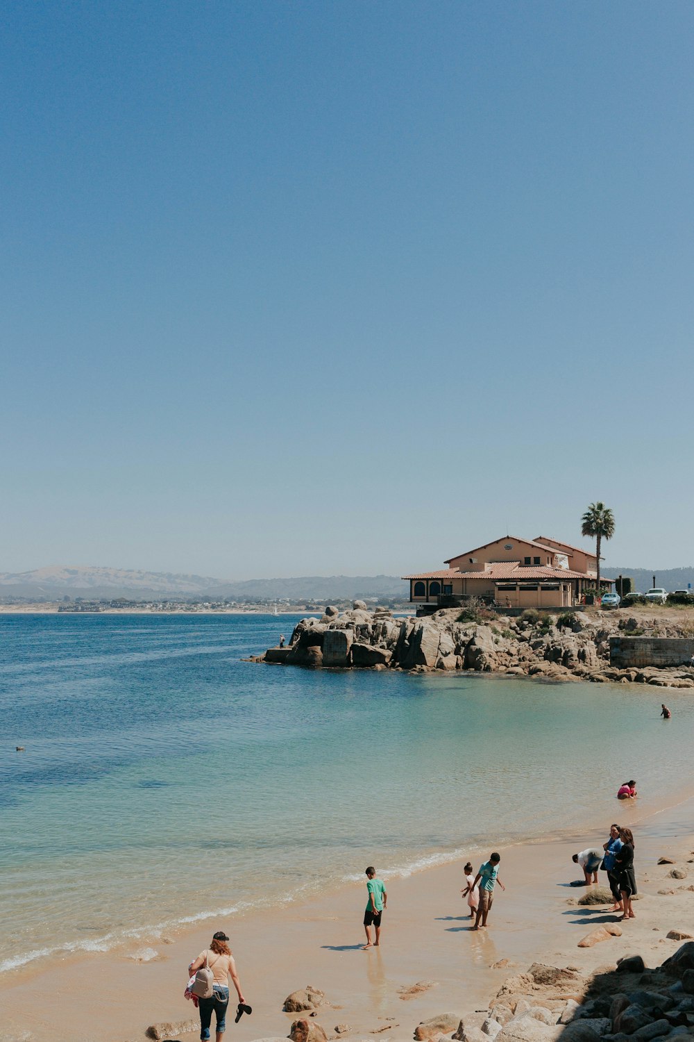 people standing on shore at daytime