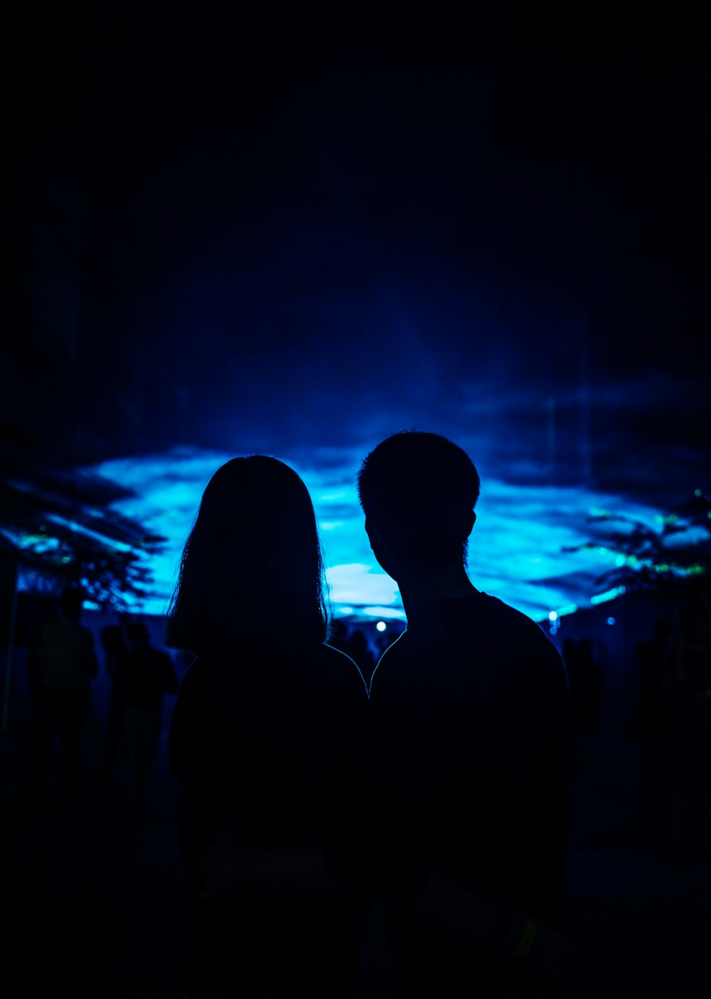 a man and a woman standing in the dark