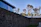 A wide shot of a modern stone wall bordering a landscaped garden with navy blue sky in the background.