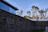 A wide shot of a modern stone wall bordering a landscaped garden with navy blue sky in the background.