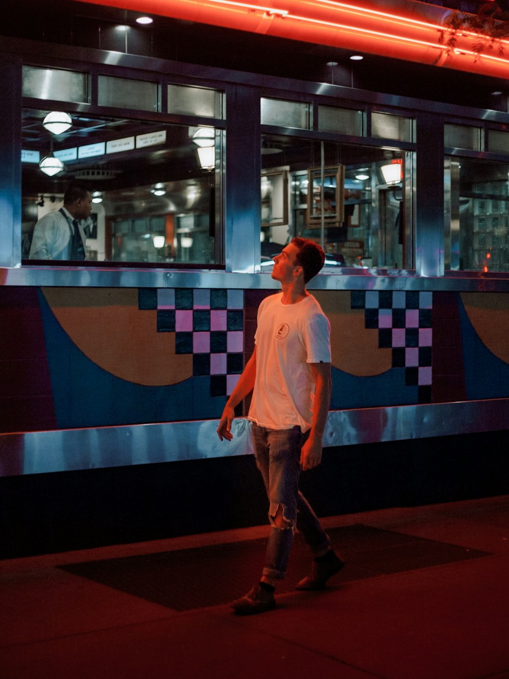 man standing beside train at night time