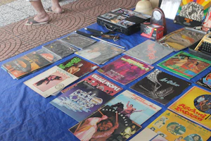 A vibrant display of colorful band t-shirts and vinyl records arranged on a rustic table