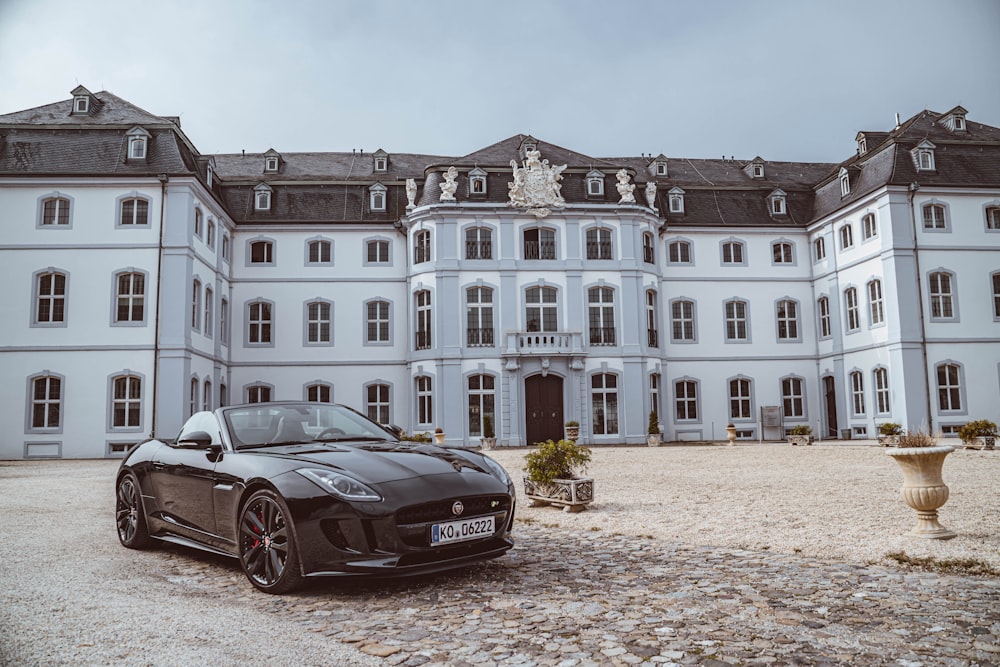 coupé sportiva nera vicino all'edificio