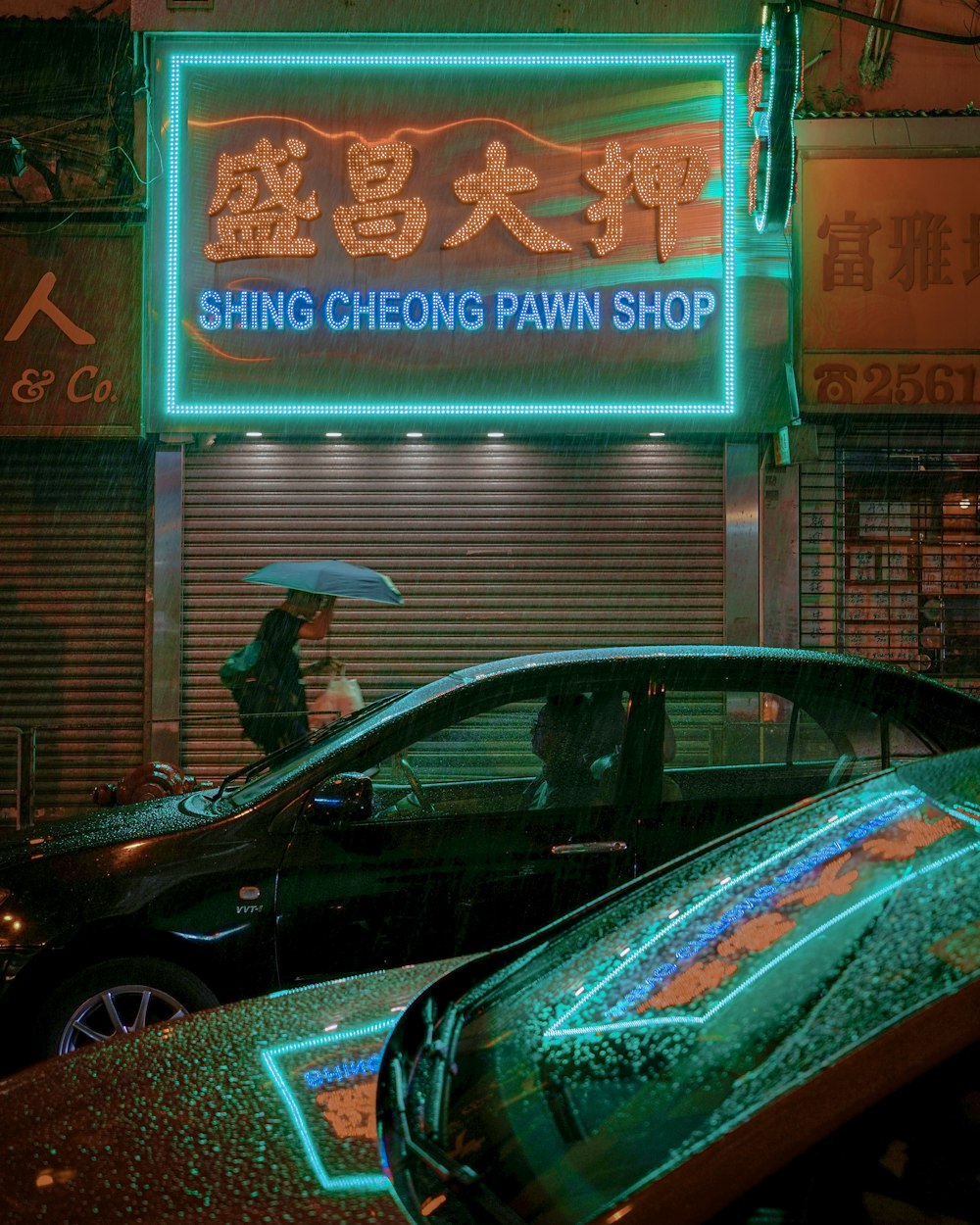 a car parked in front of a building with a neon sign