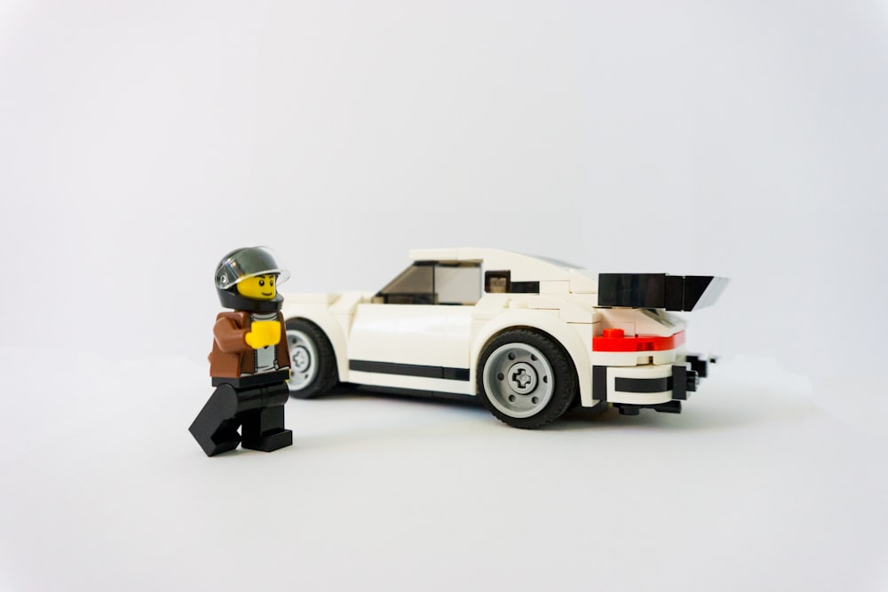Lego minifigure beside car toy