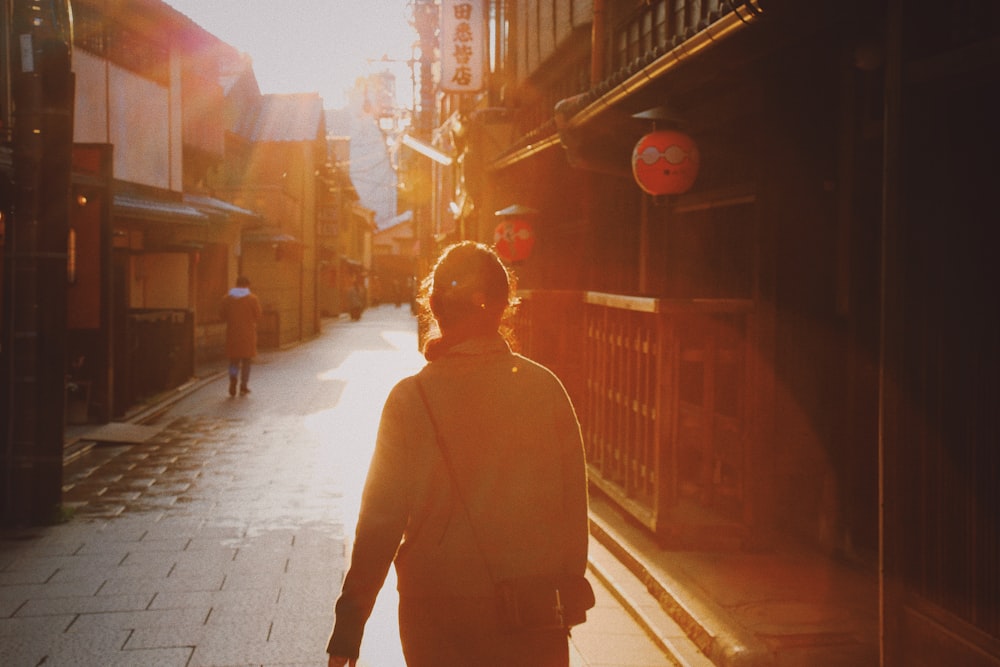 person walking on street between stores