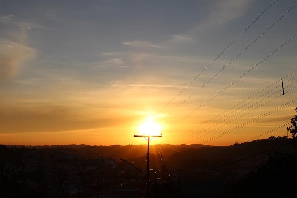 silhouette photography of electric post during golden hour