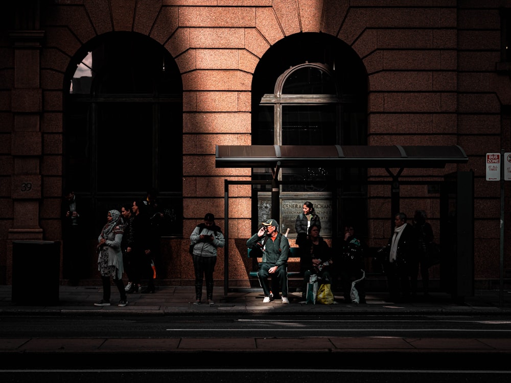 people sitting on waiting shed