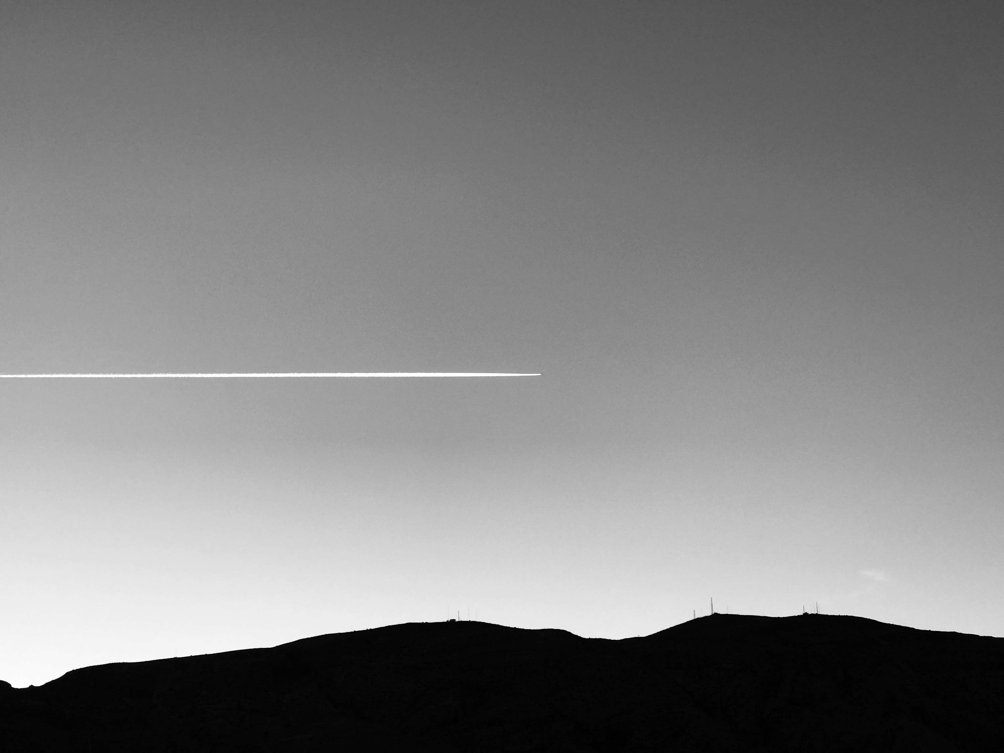 ein Flugzeug, das am Himmel über einem Berg fliegt