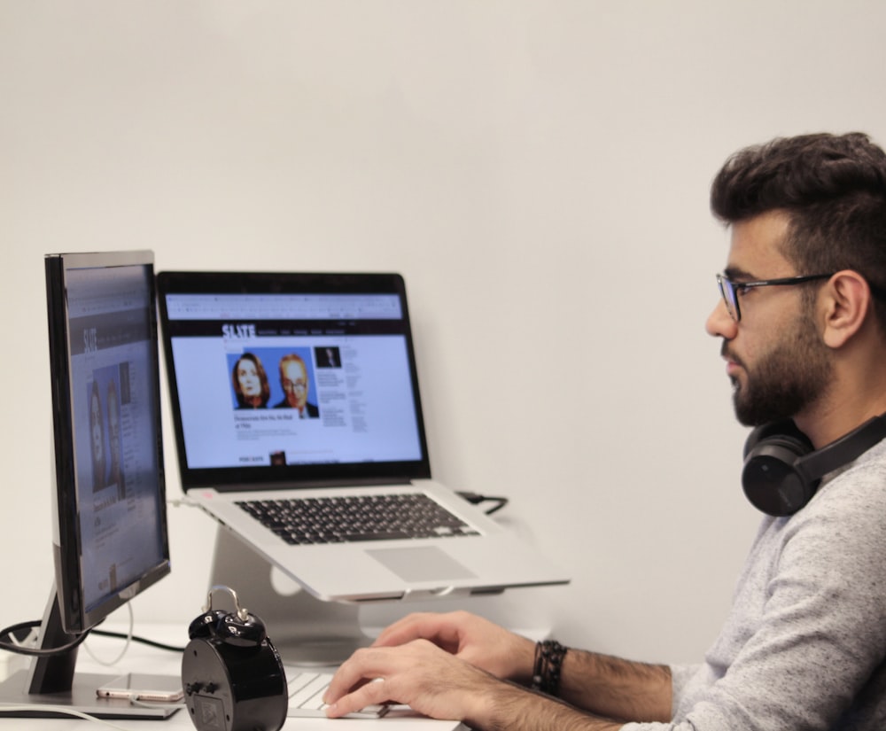 man wearing headphones using computer