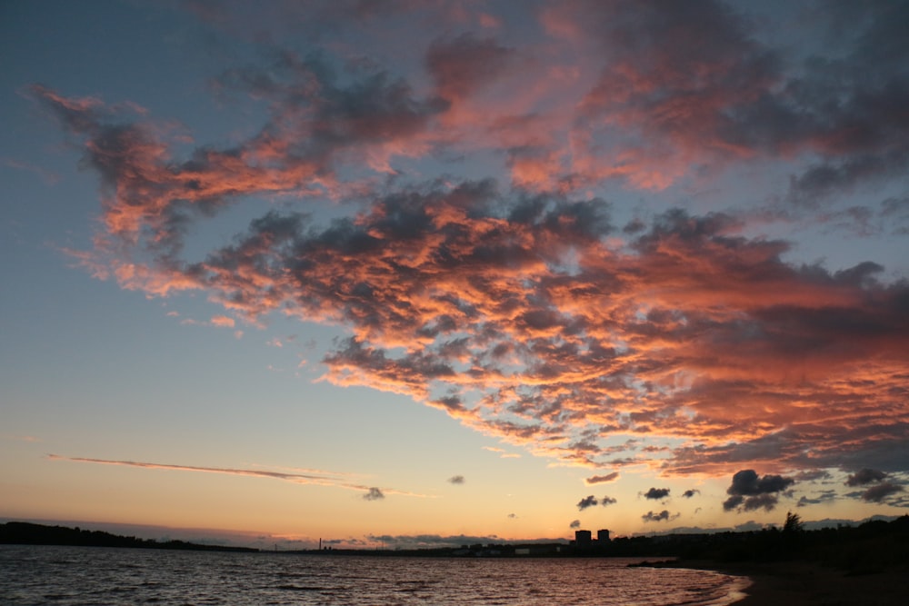 seashore under cloudy sky during golden hour