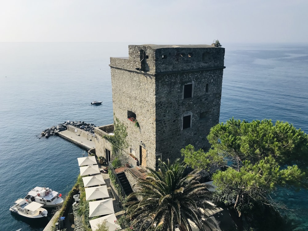 gray tower building near seashore viewing sea during daytime