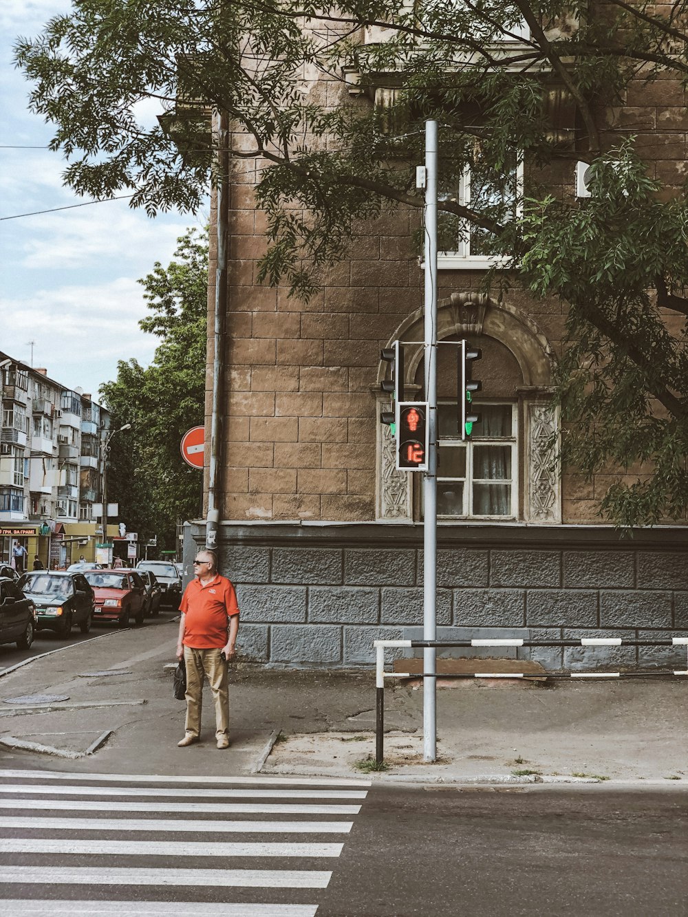 man standing on sidewalk near pedestrian lane