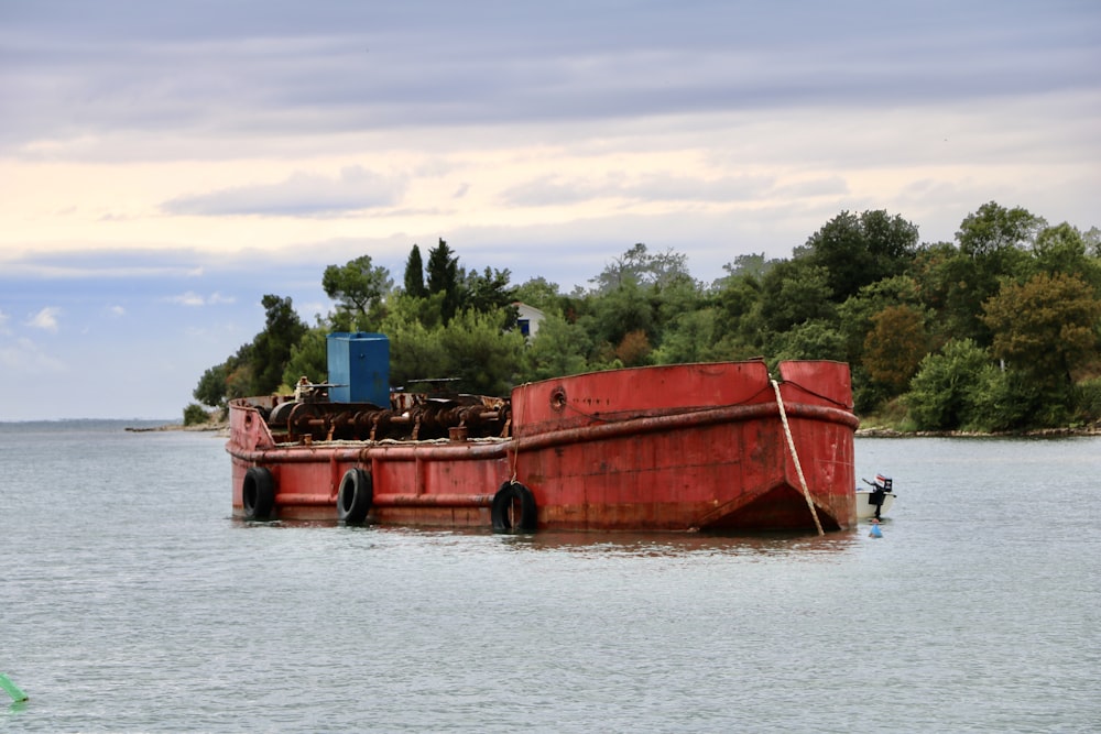 red and blue boat near trees during daytime