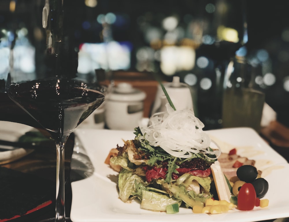 rectangular white plate with foods besides wine glass