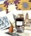 A perfume bottle labeled Boucheron Patchouli d'Angkor is surrounded by vintage prints of ancient architectural structures and Buddhist art. The background features a yellow and purple fabric with an intricate design. A small terracotta Buddha head sculpture is positioned in front of the prints.