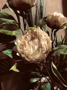 Close-up of a handcrafted bouquet featuring blush peonies and eucalyptus leaves in a rustic wrap.