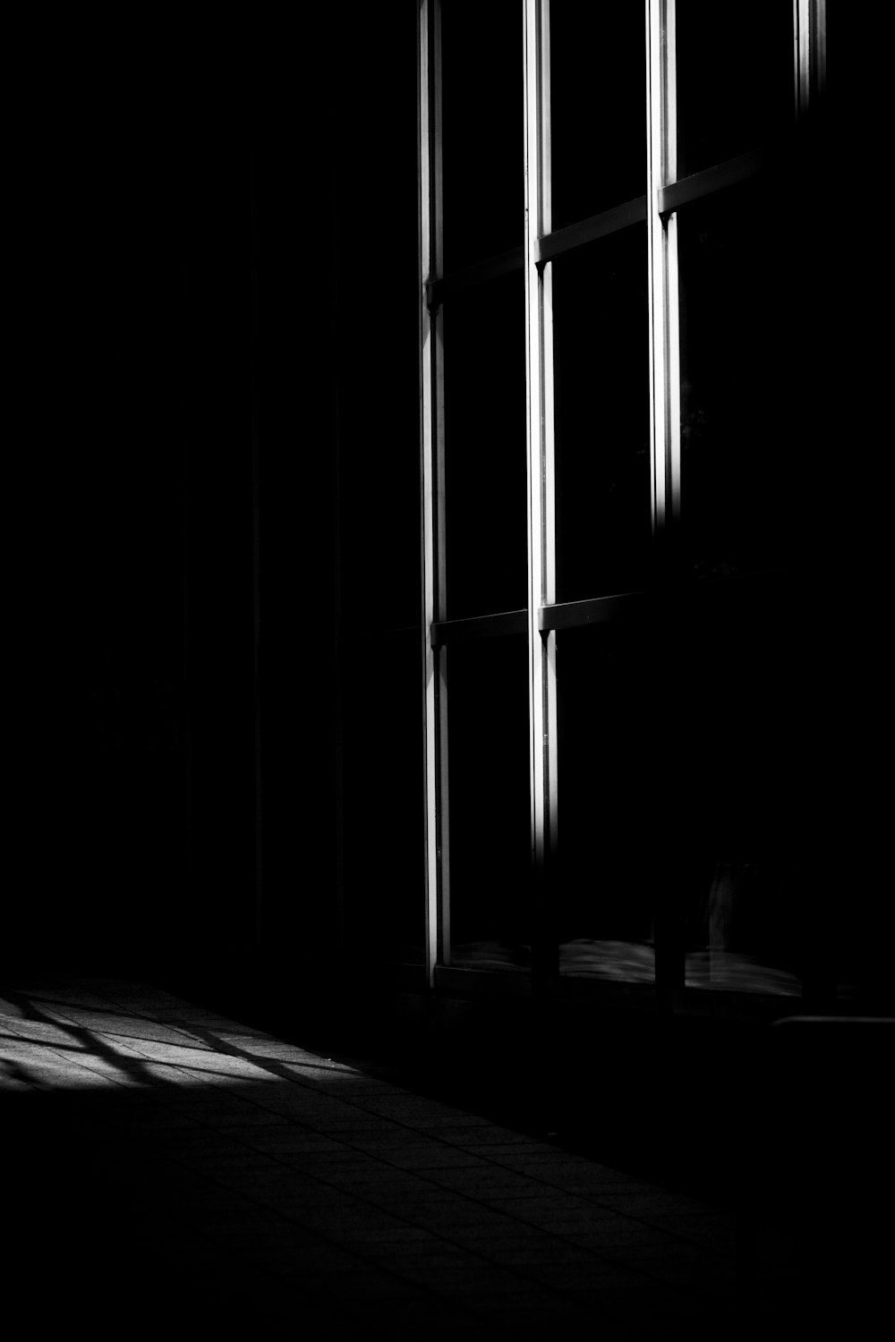 Una foto en blanco y negro de una ventana en una habitación oscura