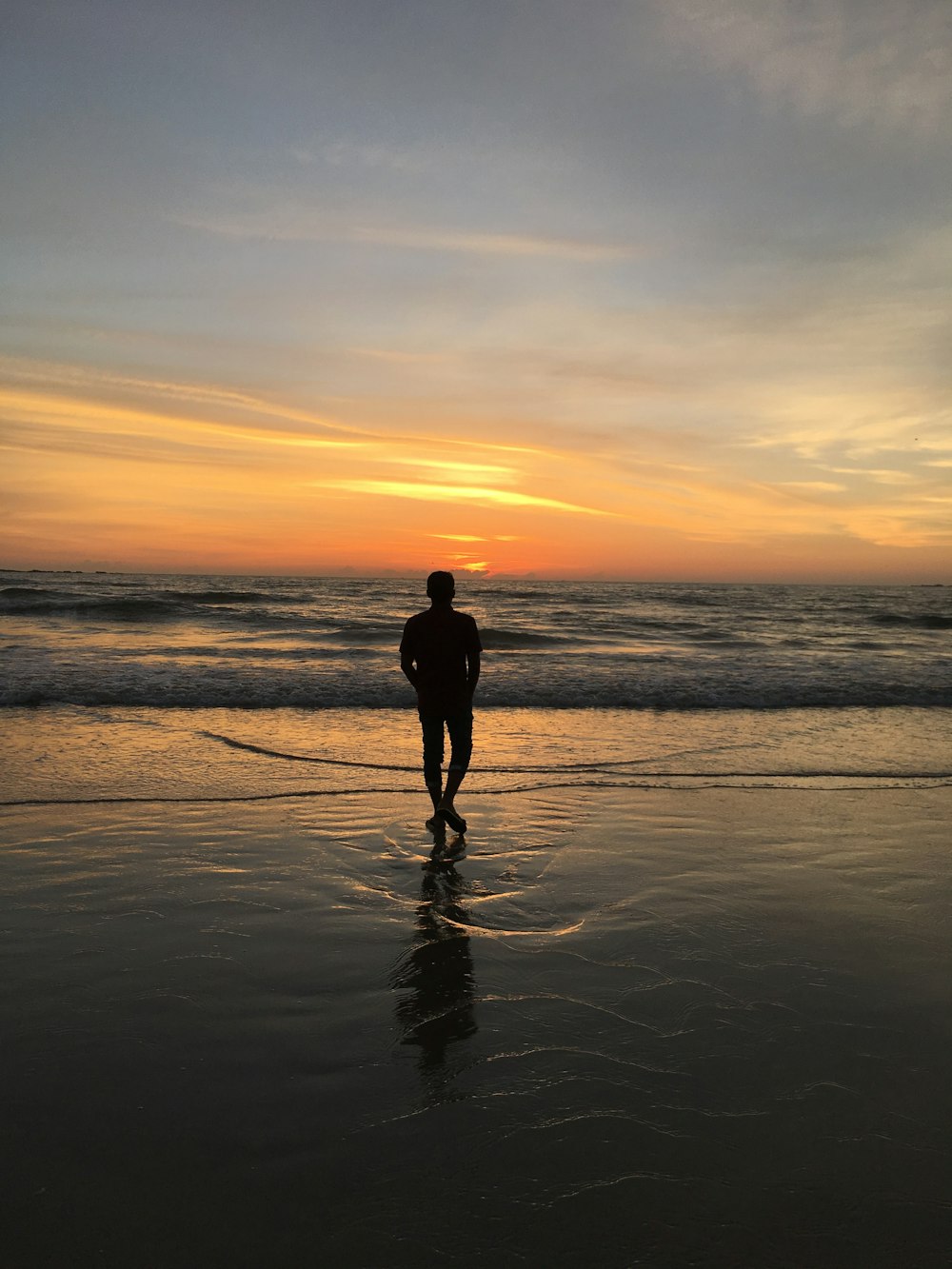 silhouette of man standing on seashore