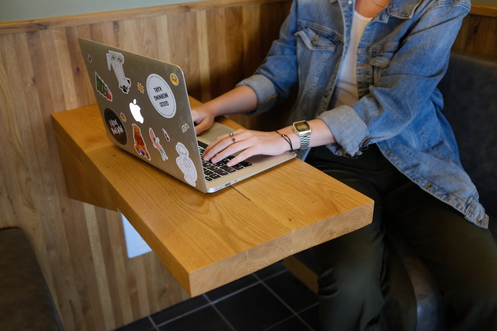 Frau sitzt und benutzt MacBook