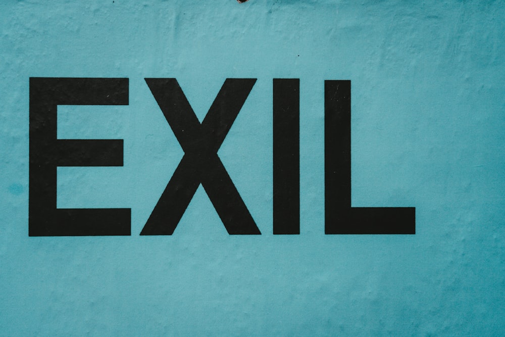 black EXIL word painted on gray wall