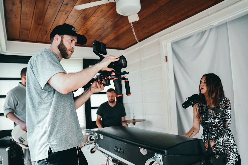 a man standing next to a woman holding a camera